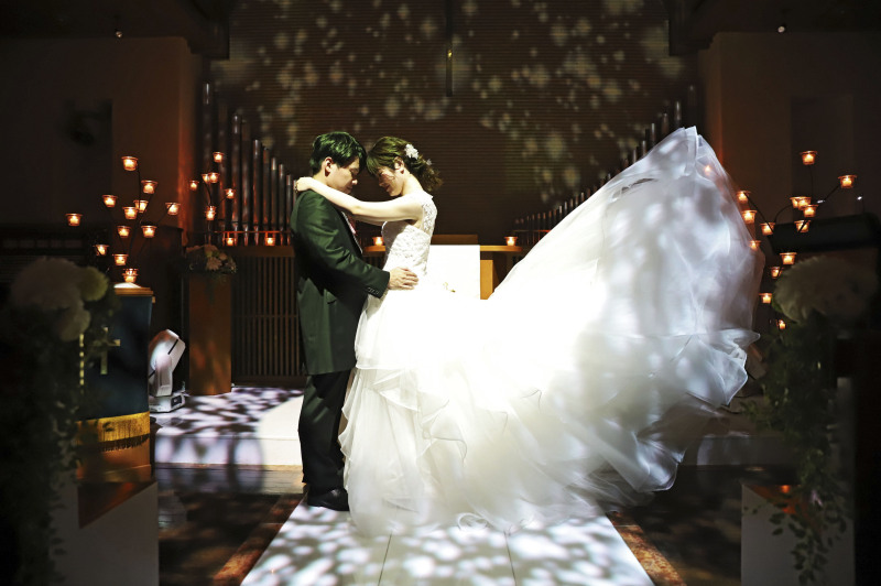 ライティングされた幻想的なチャペルでドレスのトレーンをふわりとさせて一枚