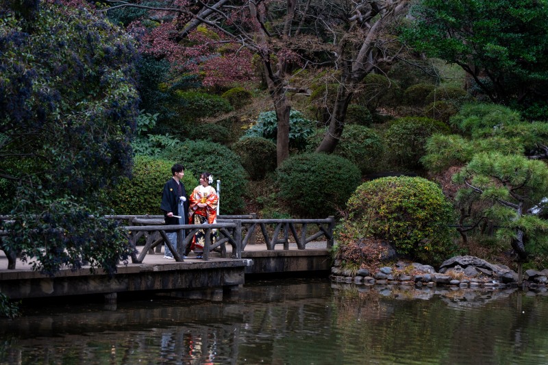 庭園の池を背景に歩むお二人