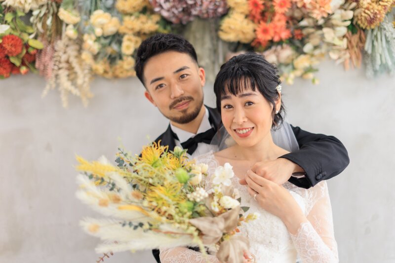 花の壁の下で寄り添う笑顔