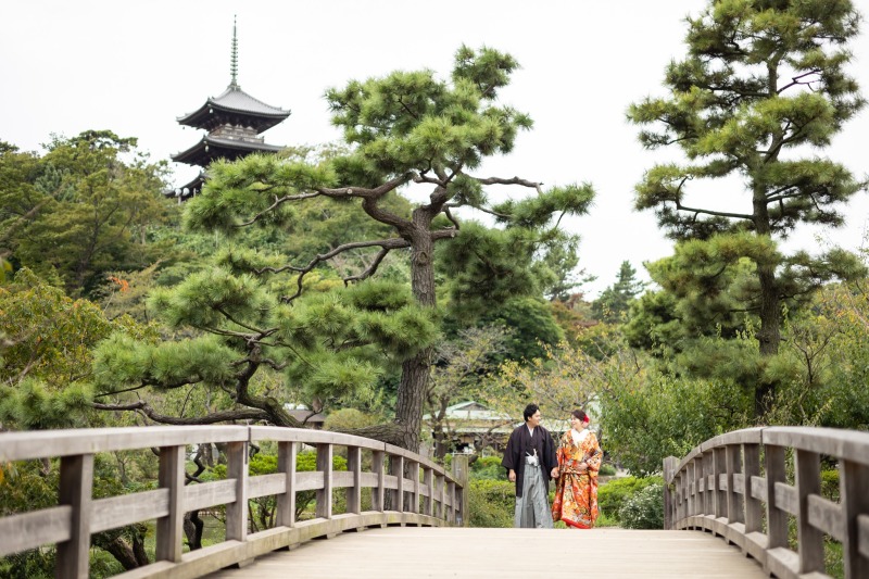 後ろから寄り添う和装の二人の手元