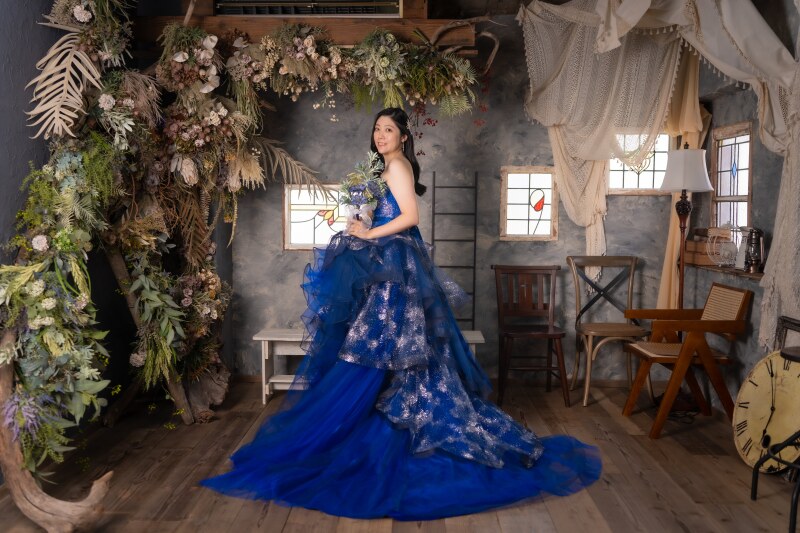 バルコニーのブルードレスの婦人背景 豪華なブルーと紺のカラードレスでシックなハウススタジオにて