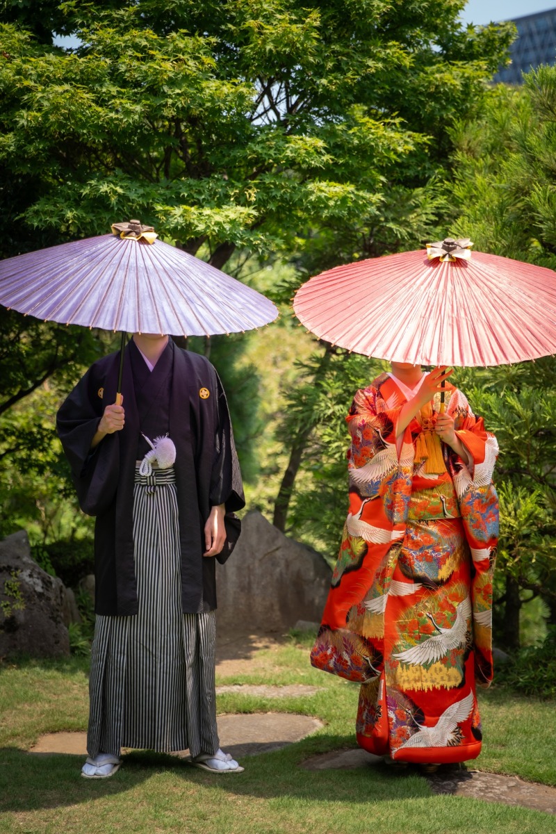 紫と朱の和傘が並ぶ庭園
