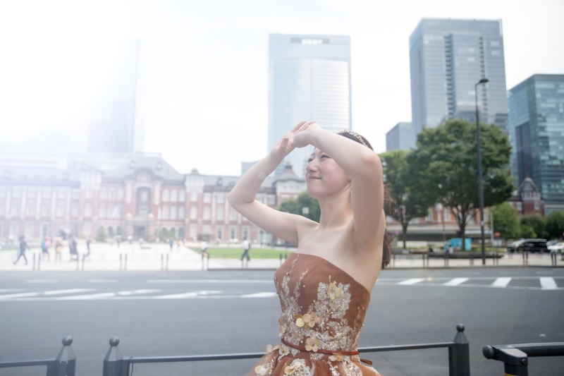 駅舎を背に空を見上げる新婦の横顔