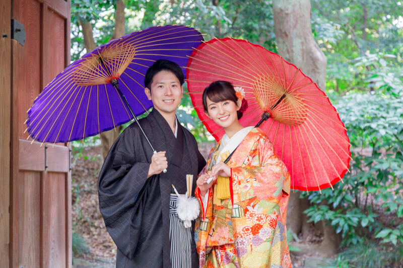 門の前で仲良く笑顔を向けて