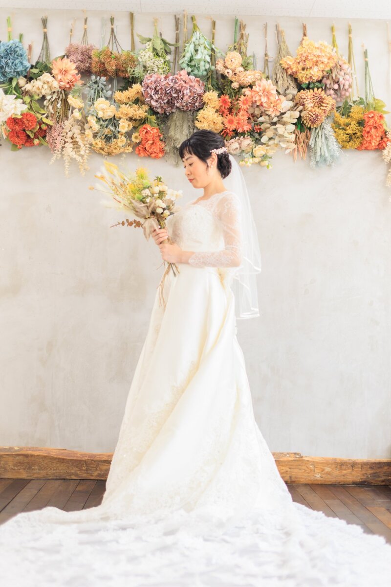 花の壁の前で佇む花嫁