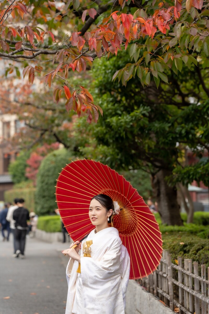 色づく桜の葉の下で微笑む花嫁