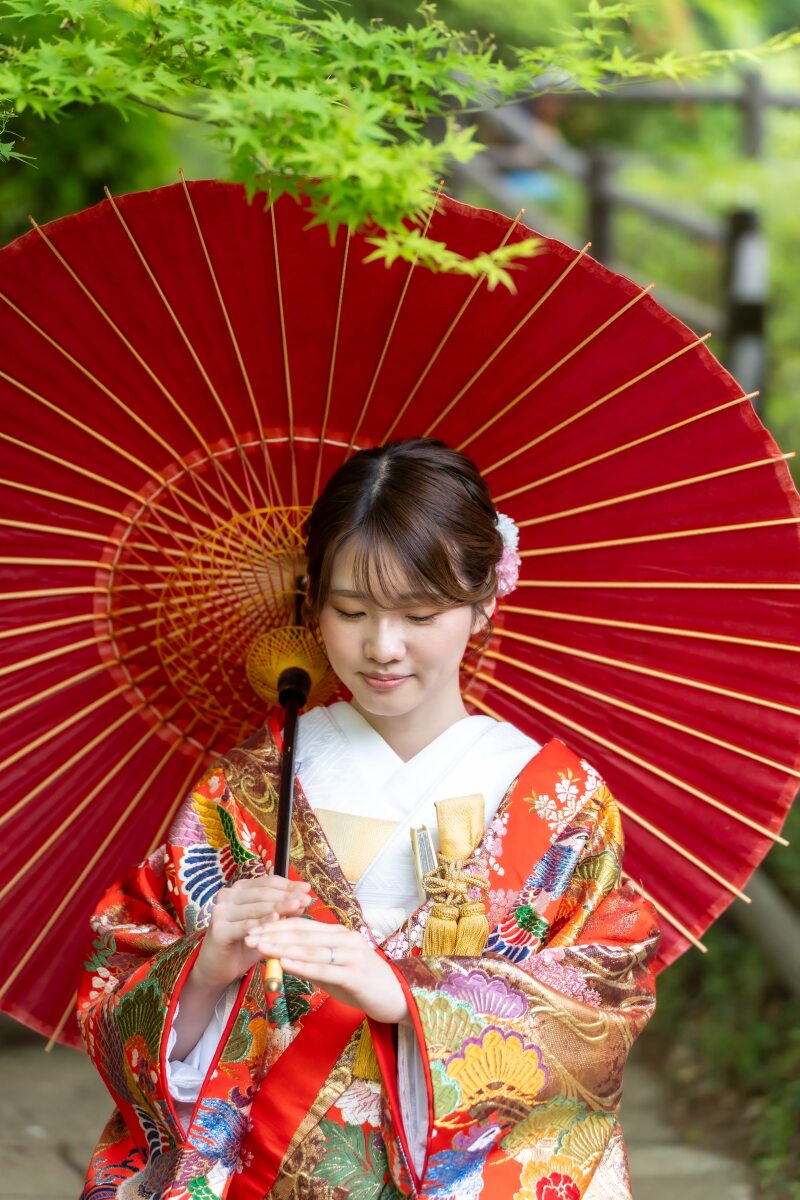 赤い和傘に包まれるご新婦様