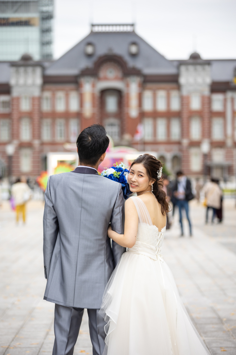 肩越しに振り返る新婦、東京駅前で
