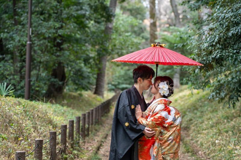 赤い番傘の下、見つめ合う