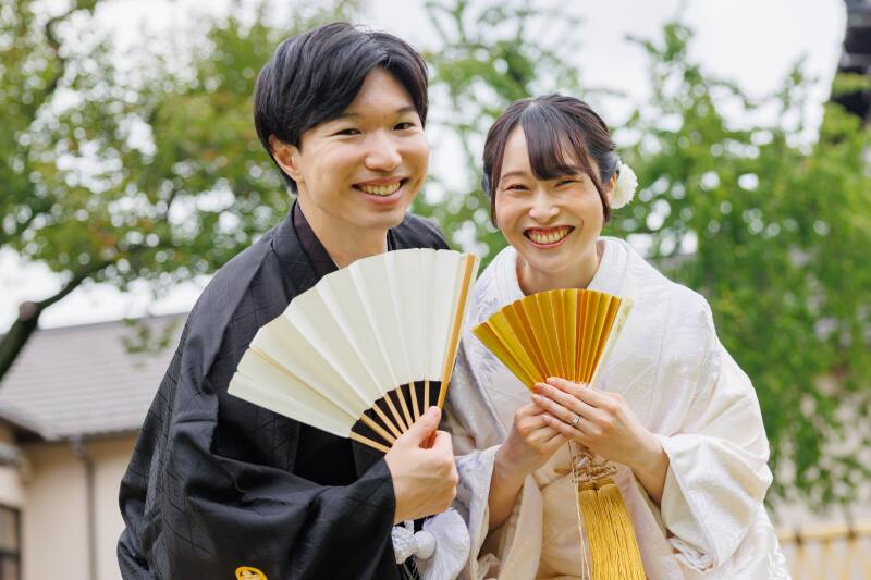扇子を使ってニコニコ笑顔で