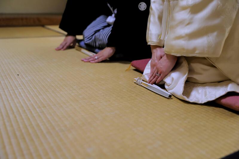 和室で触れ合う扇と指先