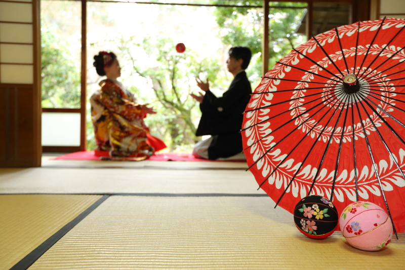 和風小物にピントを合わせ奥にはおふたりをボカシておふたりの表情がみえるかどうかぐらいのボカシ具合に