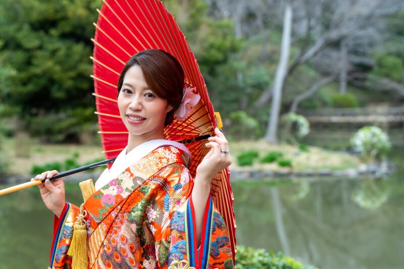 水辺を背景に晴れやかな笑顔
