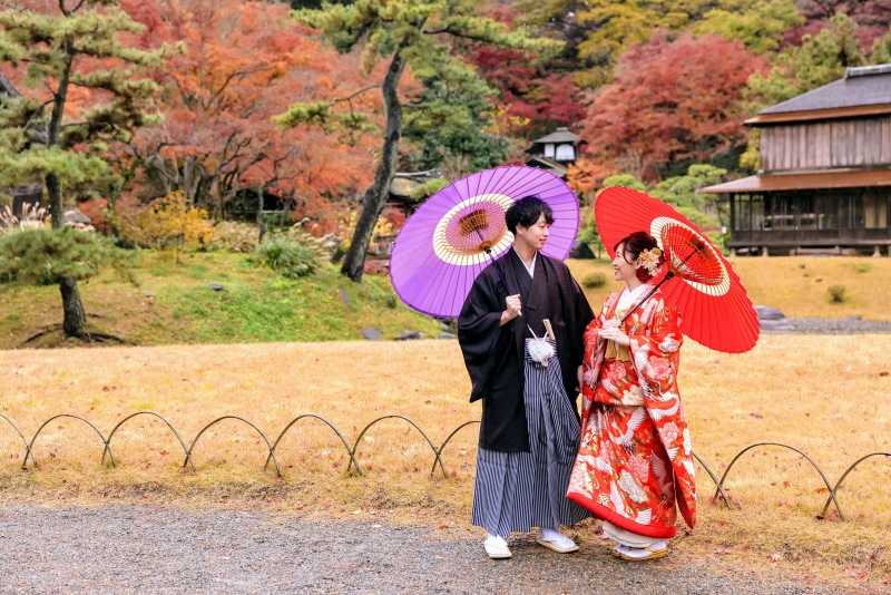 日本家屋と紅葉をバックに