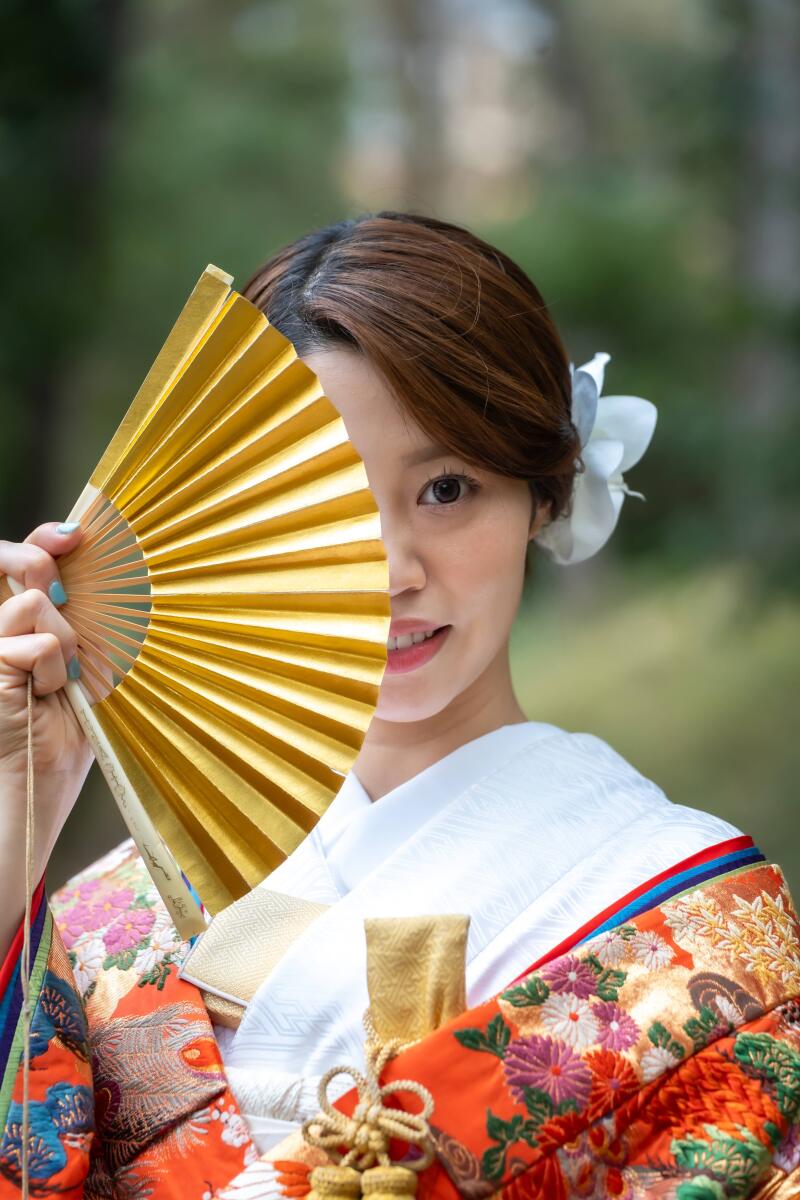 金色の扇子から覗く魅力的な瞳