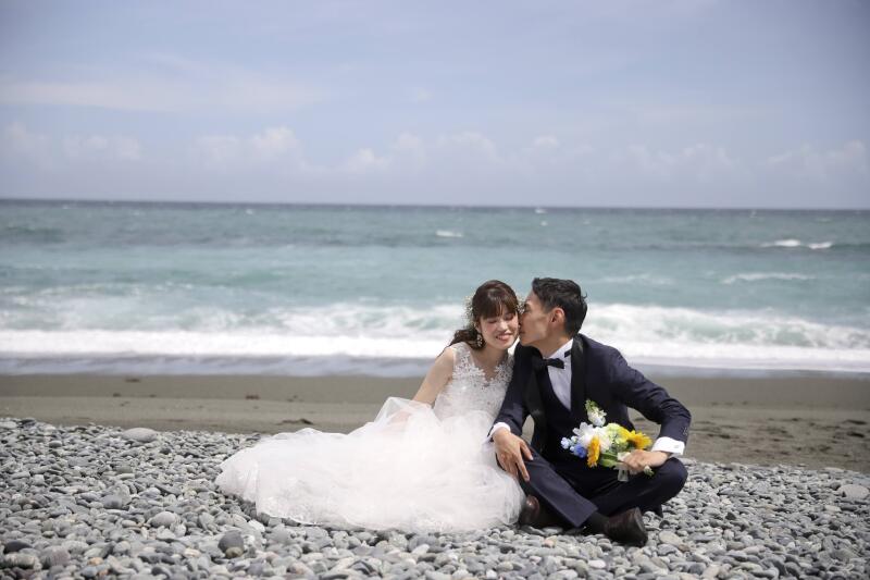海をバックにほっぺにチュー