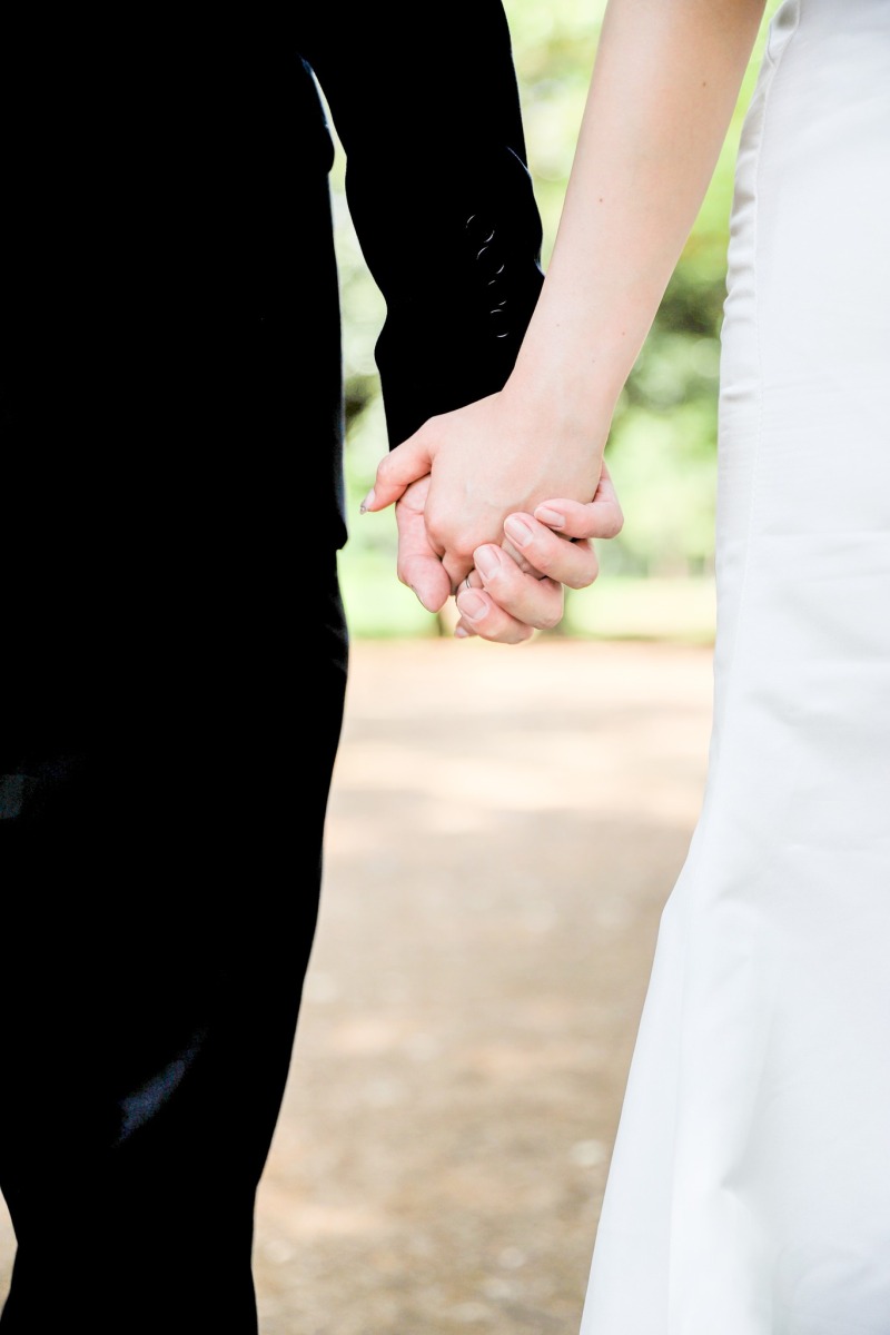 緑の並木道で重ねる手元と結婚指輪