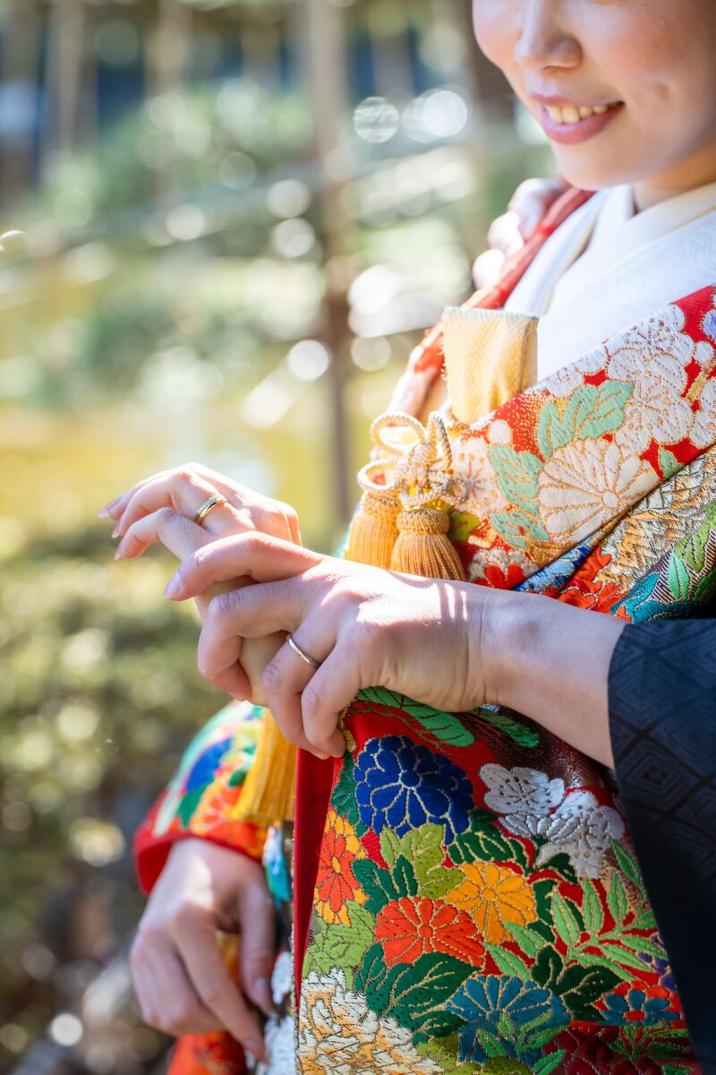 指輪に触れる仕草と口元の笑み