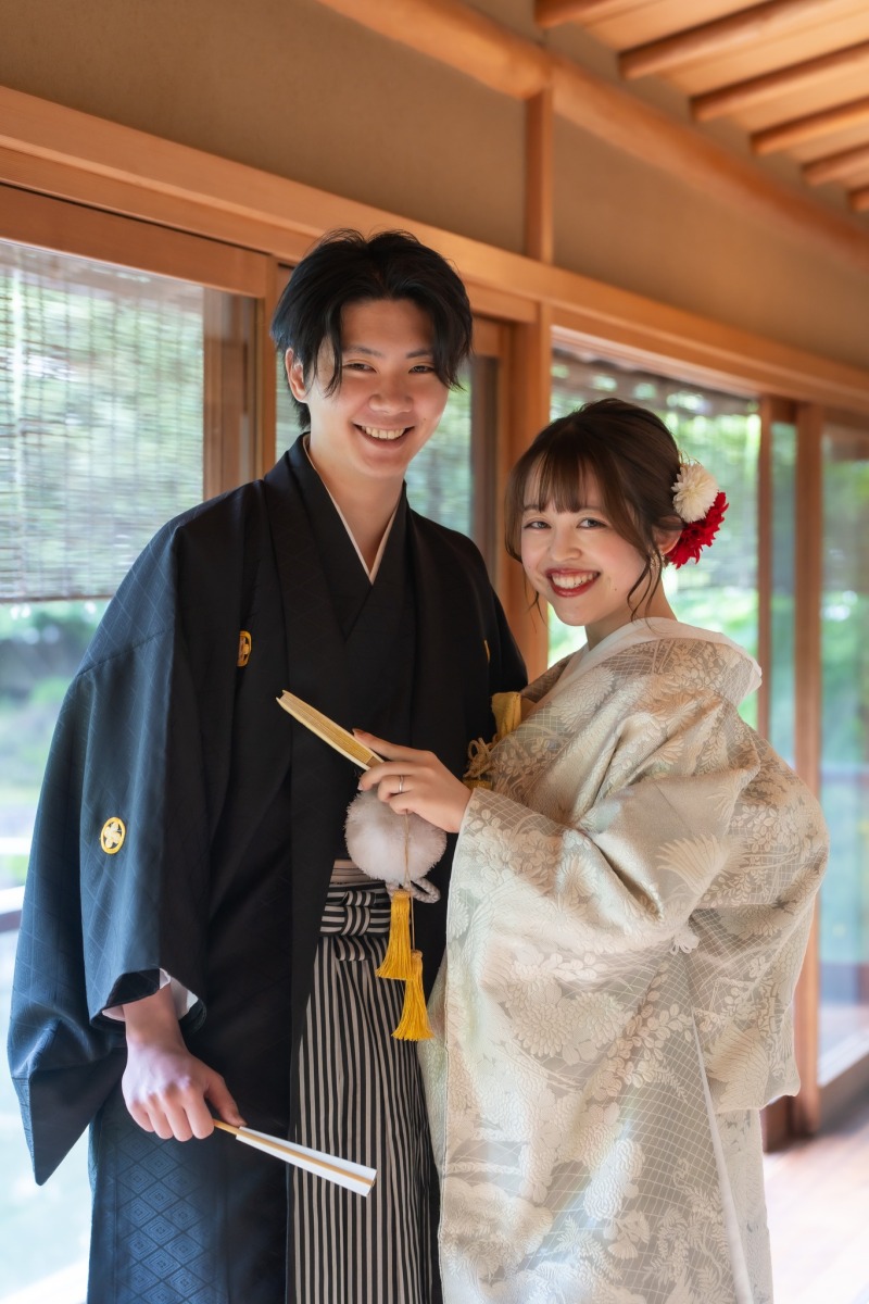 扇子を手に笑顔で