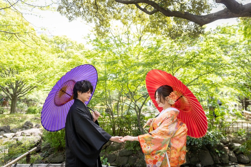 自然に囲まれて手を取り合う二人のカット