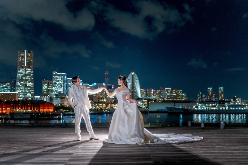 夜景をバックにご新郎様がご新婦様の手を引くカット