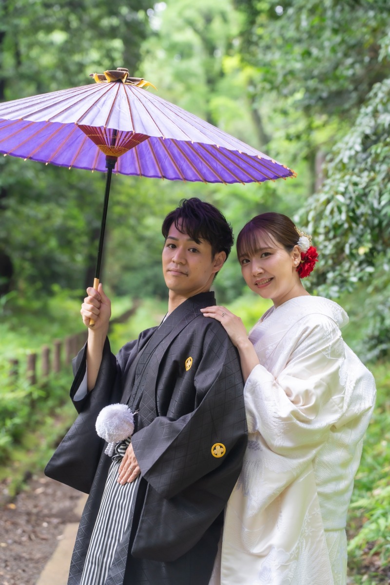 紫の和傘を掲げて寄り添う二人
