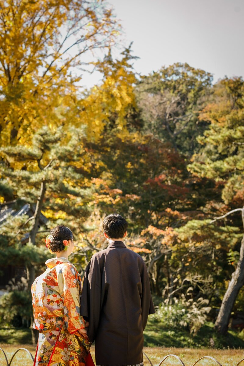色づく紅葉の中を歩む二人