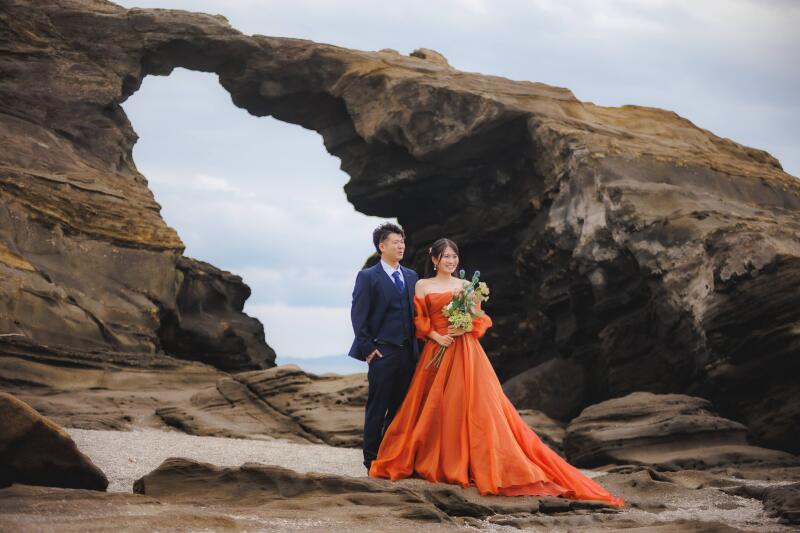 壮大な岩場を背景に愛を誓う