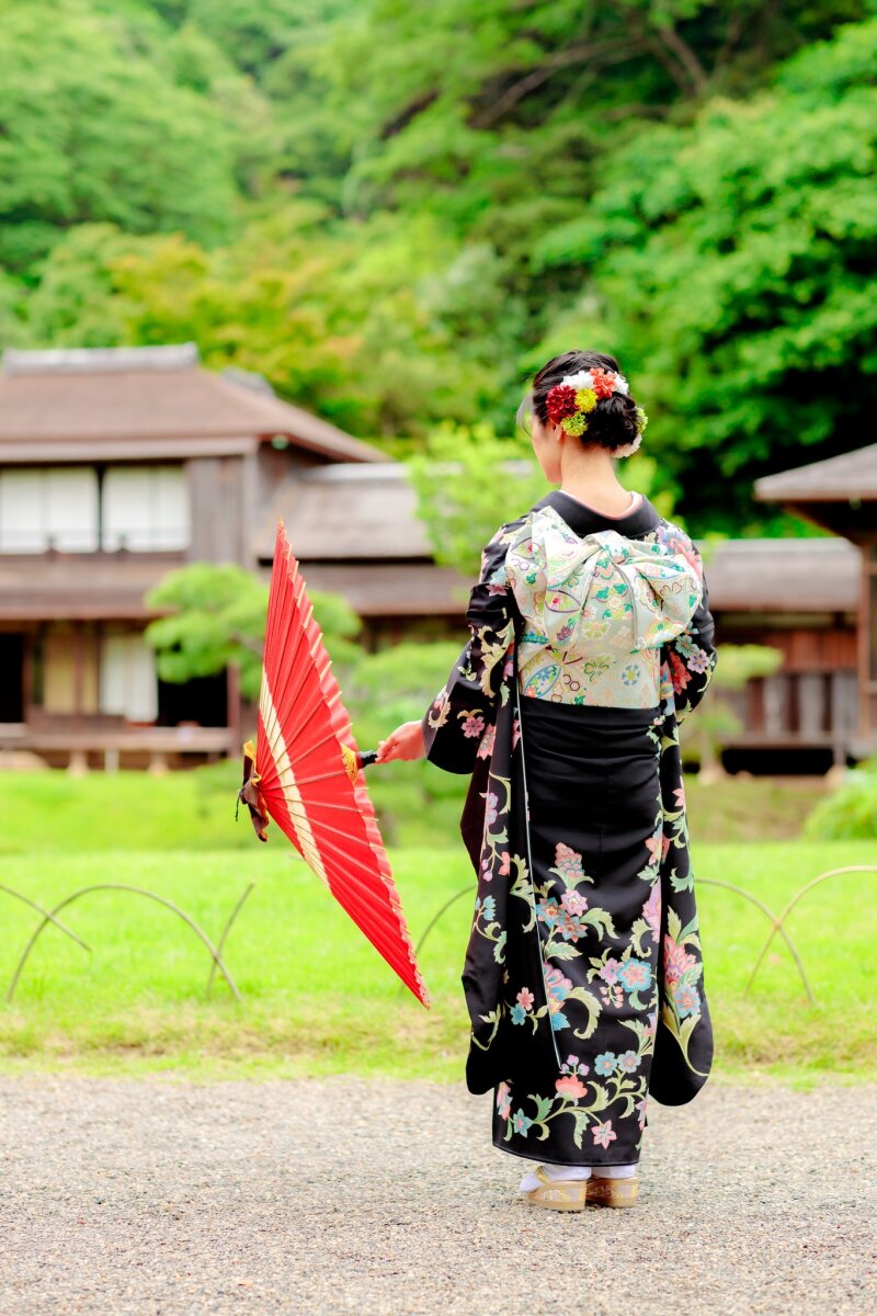 紅い和傘を手に佇む後ろ姿