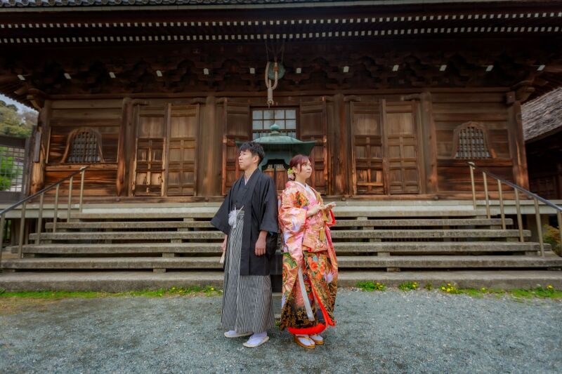お寺の本殿をバックに背中合わせカット