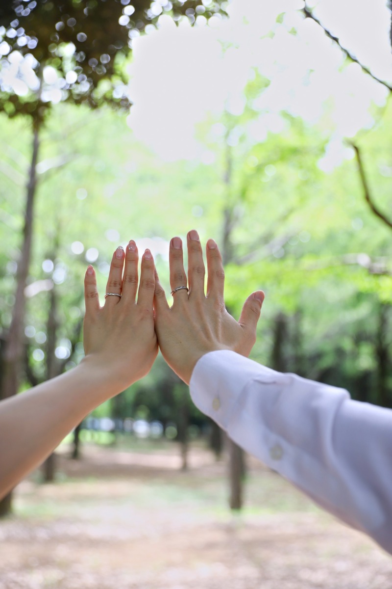 木漏れ日の下で重ねる手のひらと結婚指輪