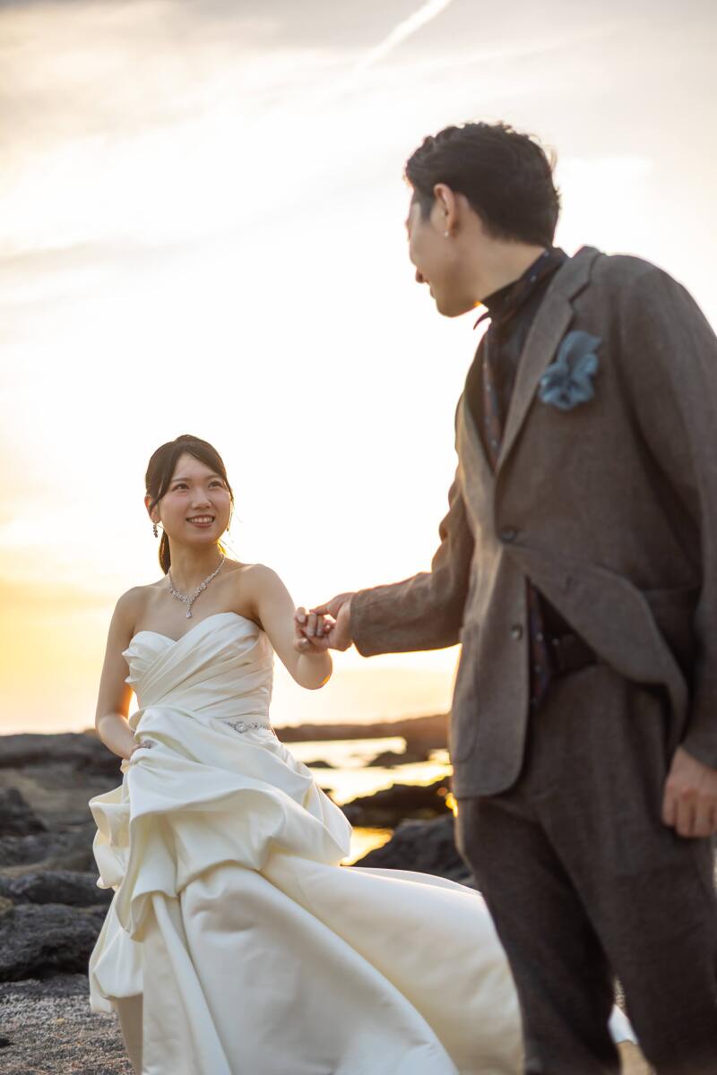 夕日を背に手を引かれているご新婦様