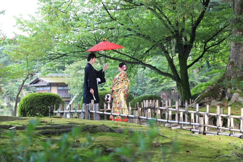 緑を背景に番傘を持ちながら