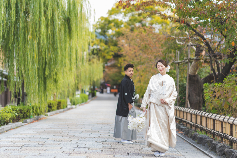 柳の下で真っ白なブーケを手に