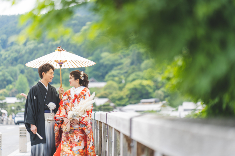 木陰から覗く相合傘をする姿