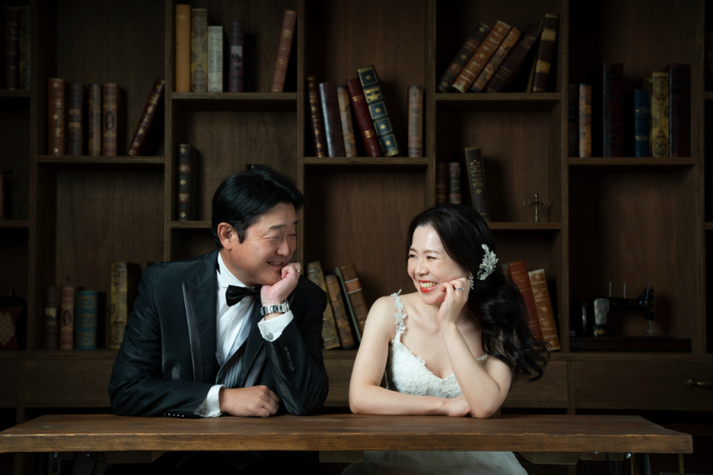 洋書並ぶブックシェルフを背景に