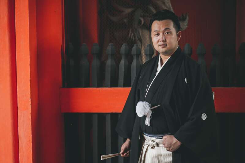 朱色の背景にクールに決める新郎様