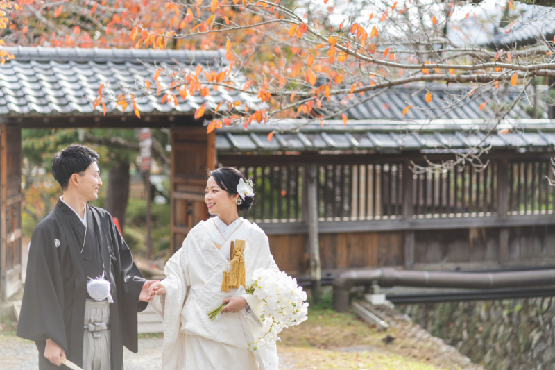 紅葉の下、手を取り合って進むおふたりの姿