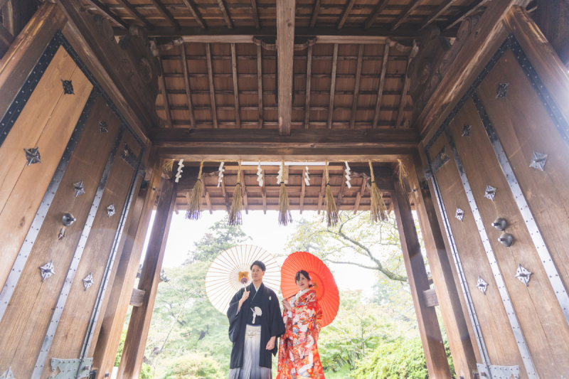 大きく開いた門の前で小物を合わせて