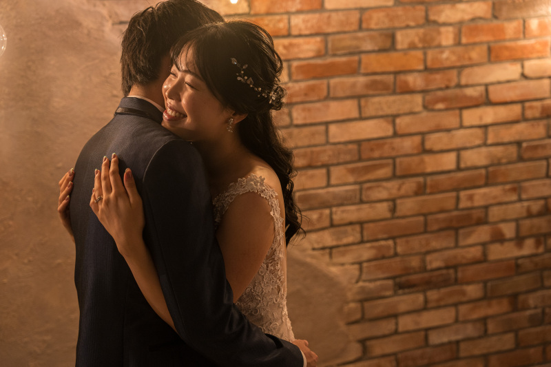 レンガ調のスタジオでドラマチックなハグショット