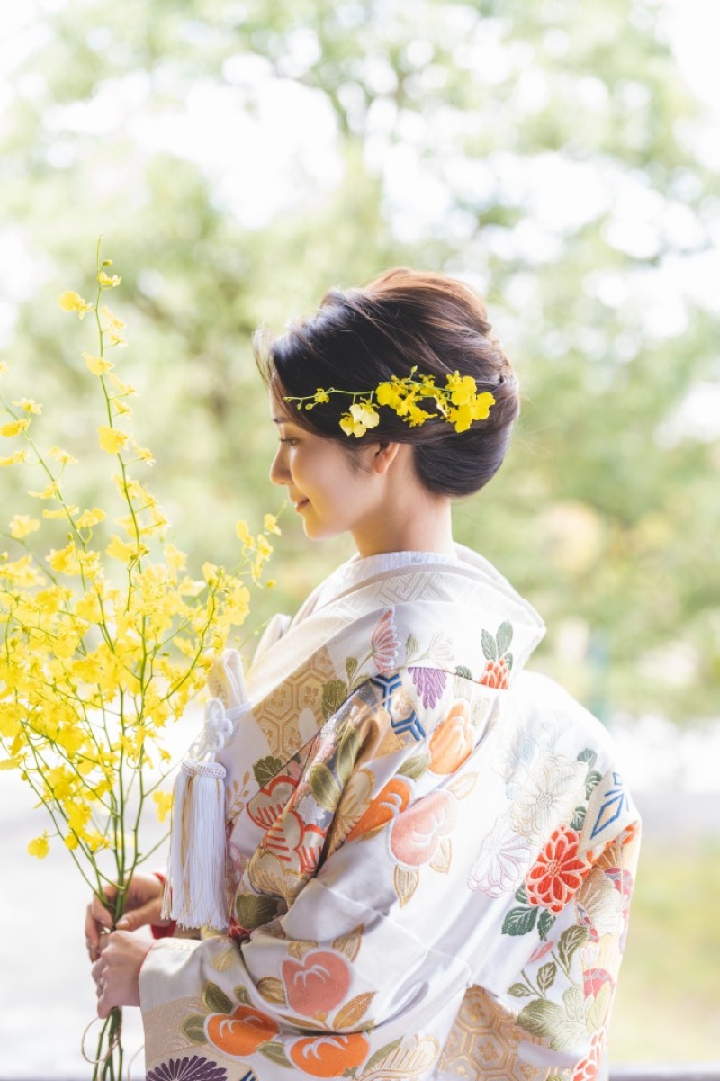 色打掛の淡い色と菜の花のはっきりとした黄色が相まって、可愛らしい雰囲気が素敵な一枚です。