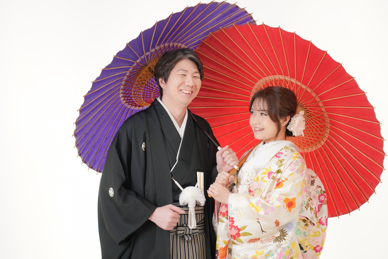 赤と紫の和傘に包まれて、こぼれる満開の笑顔