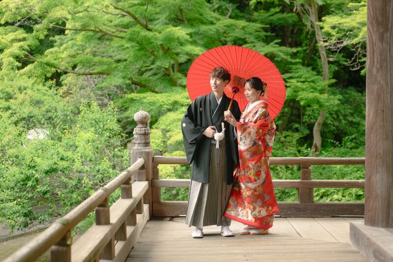 赤色の和傘が引き立つ新緑の回廊