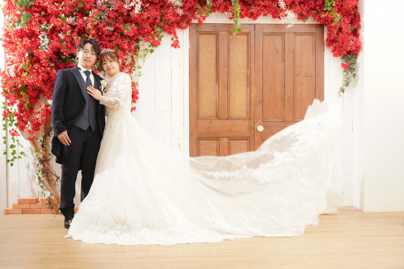 映画の1シーン。赤の花と木扉が奏でる大人のロマン