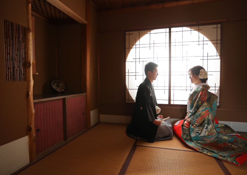 川上別荘内の丸い障子の前で