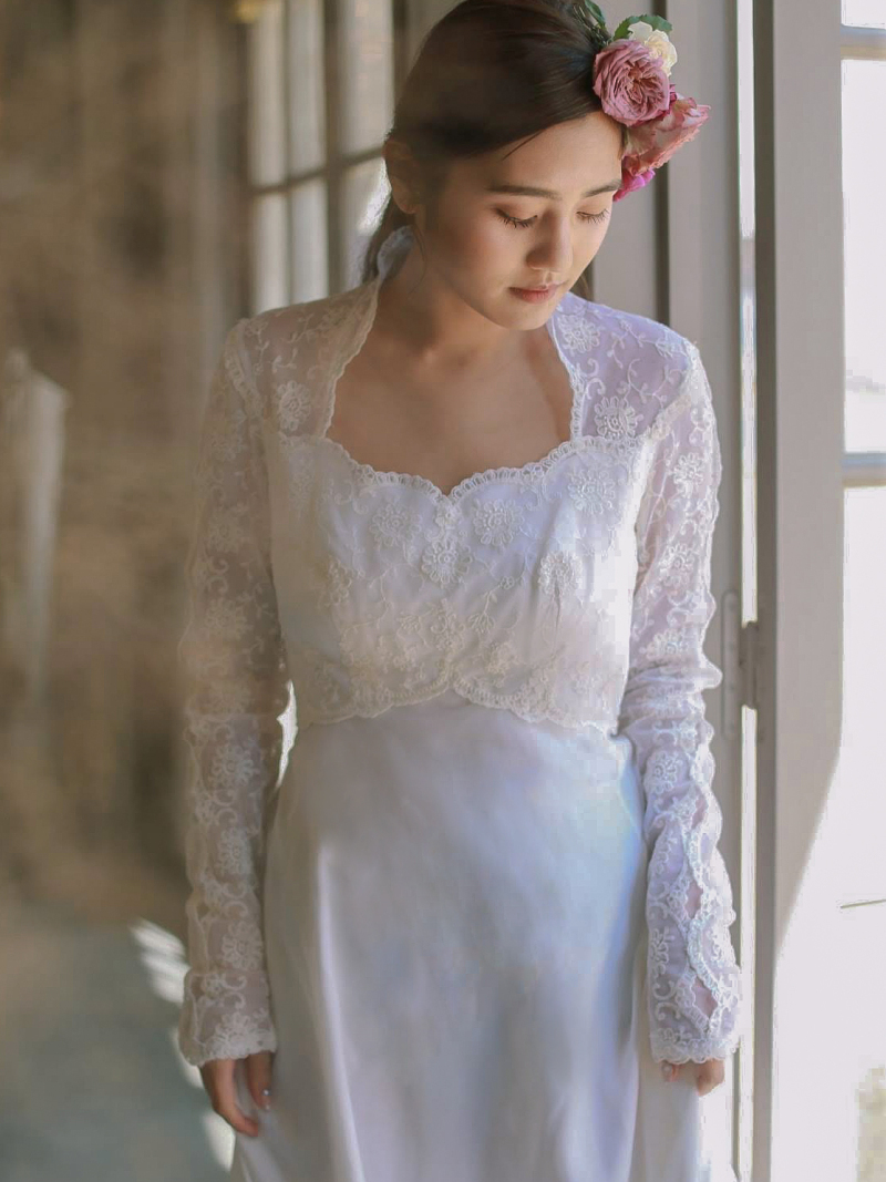 レースのスリーブとデコルテ部分のデザインが素敵なドレス。シンプルなヘアスタイルで海外風な1枚。