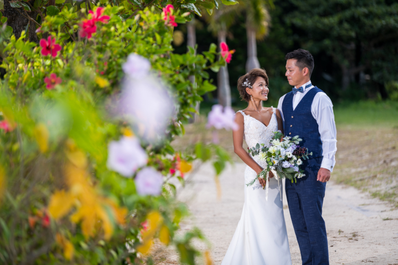 沖縄の自然は海だけではありません。色鮮やかなお花や南国らしい緑の樹々もステキです。おふたりを祝福するような、自然にあふれたロケーションの中、やさしい眼差しでおふたりが見つめ合う美しい一枚になりました。