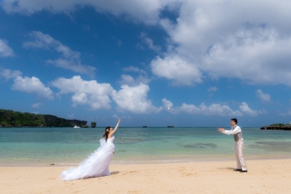 エメラルドグリーンの海と青い空を背景に、ビーチでドレス＆タキシードを着て楽しむキャッチボール。非日常感のフォトウエディングの空間で、日頃のおふたりのなかよしさを感じさせる、自然なショットになりました。