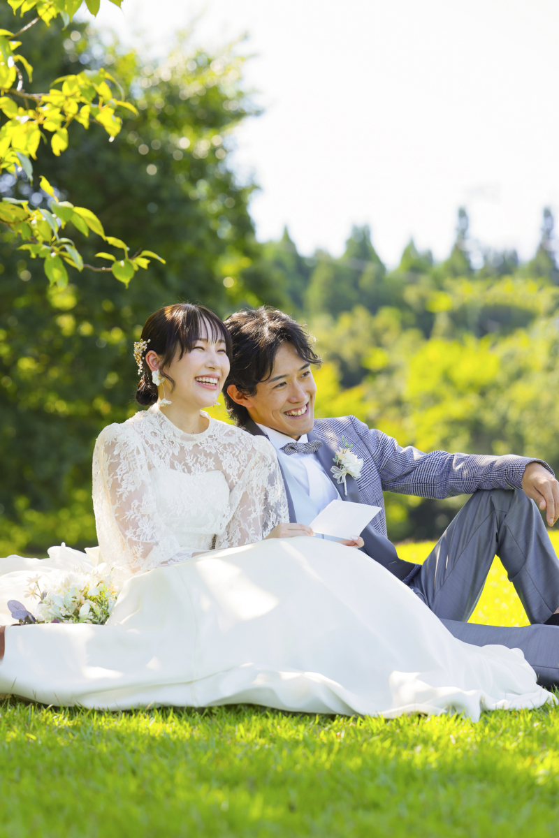 芝生に寄り添って座る自然体ショット