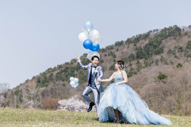 青空の下、笑顔が弾けた瞬間をキャッチ！おふたりらしい明るさと軽やかさを、そのまま写真に閉じ込めました。見るたび元気になれる1枚です。